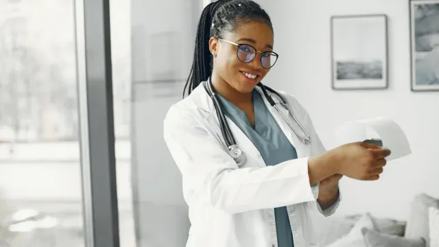 A veterinarian in an exam room reading the ingredient panel on a dog supplement bottle