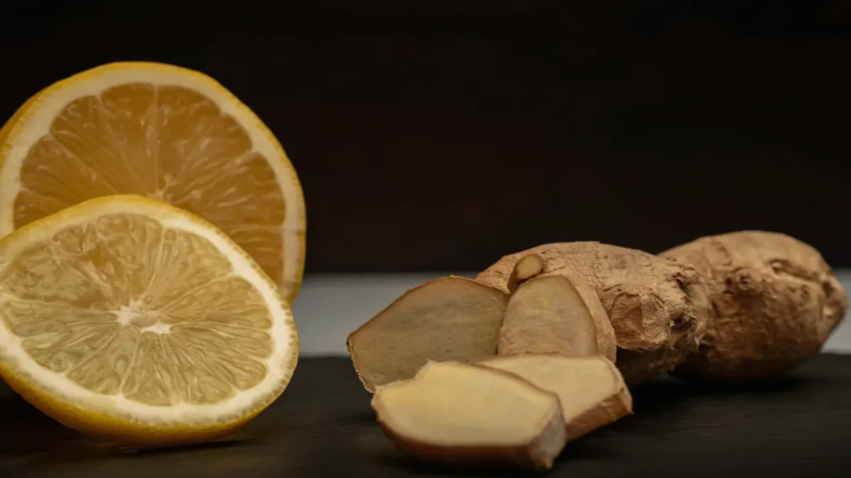 Fresh ginger root and sliced pieces beside a stainless dog bowl