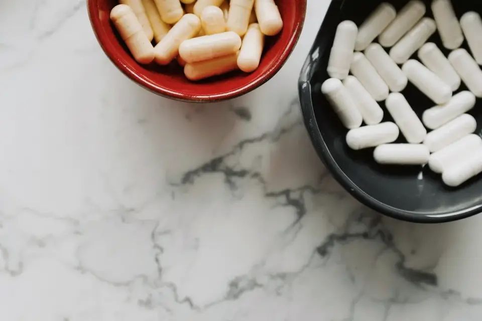 Soft chew supplements poured into a small bowl beside their bottle